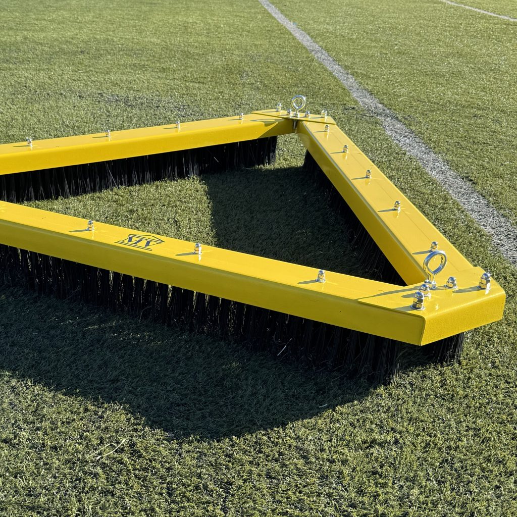 Cepillo Triangular Rastra Color Amarillo sobre Césped Sintético